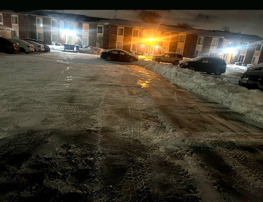 Parking lot cleared overnight, lit by the property's lights