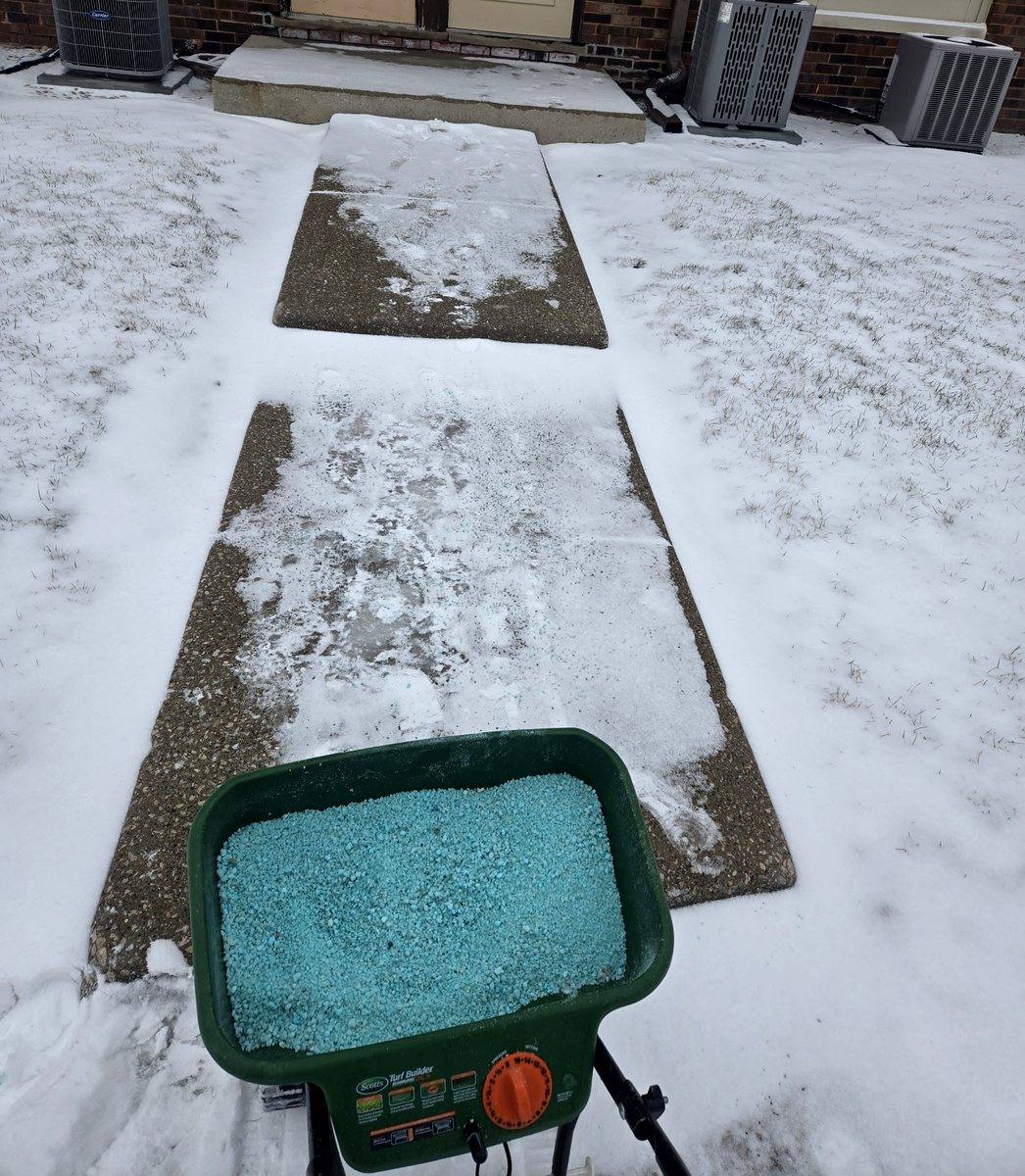 Walkway cleared to bare concrete with a spreader of ice melt ready to go down